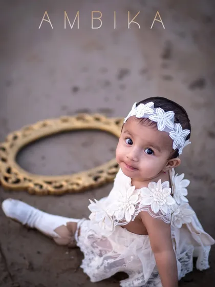 A beautiful, artistic portrait of a one-year-old on the beach. The composition and her curious gaze make this a truly special image.