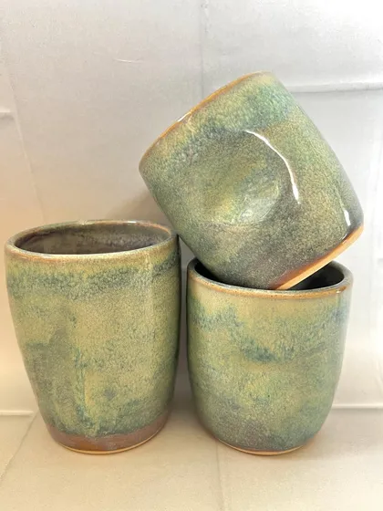 A set of three turquoise grip mugs, showing their comfortable, ergonomic shape.