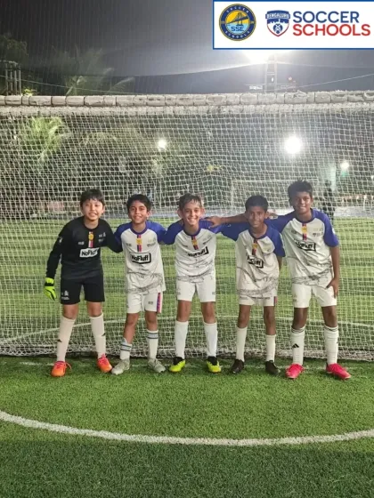 A U10 team photo under the lights after a match.