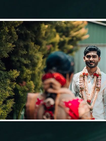 A creative "first look" style shot, with the focus on the groom's reaction as he sees his bride for the first time.