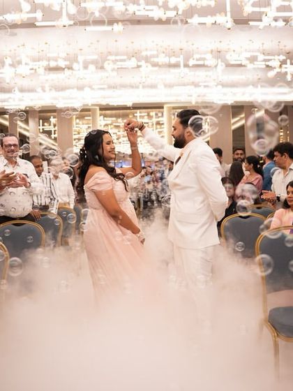 The parents-to-be making their entrance through a cloud of bubbles and dry ice, creating a truly magical and dream-like start to their baby shower celebration.