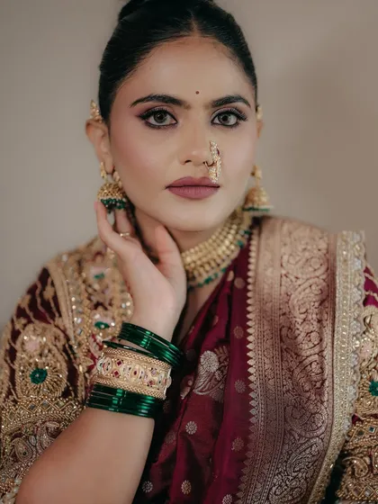 A direct, confident gaze. The makeup enhances her strong features, with perfectly sculpted brows and a flawless matte base that stands up to the camera.