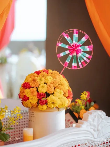 A vibrant marigold centerpiece accented with a handcrafted pinwheel. This playful detail perfectly captured the fun and nostalgic spirit of the Haldi Mela.