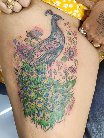A royal peacock tattoo is a symbol of beauty and pride. I love working with color to create vibrant, timeless masterpieces like this one. We designed this piece to flow perfectly on the thigh, making it a bold and elegant statement.
