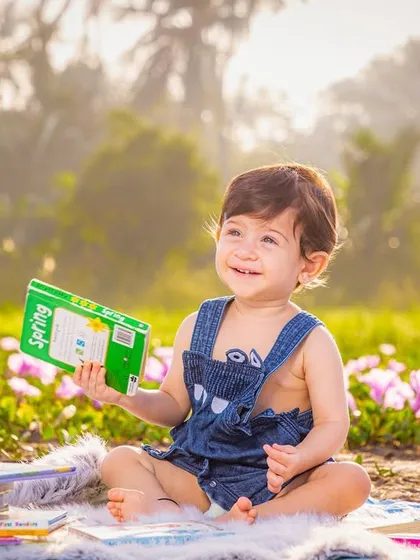Capturing a quiet, candid moment during an outdoor toddler session. The soft natural light and beautiful field of flowers create a perfect, relaxed setting for your child's personality to shine.