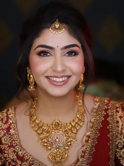 A radiant reception look, featuring a flawless airbrush base, softly defined eyes, and a natural lip color that enhances her beautiful smile. This close-up showcases a smile that says it all.