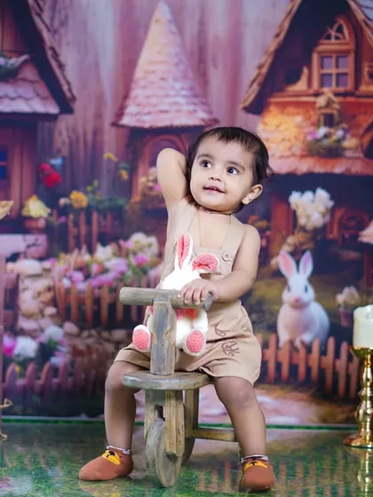 A little girl enjoys a ride on a wooden tricycle in our whimsical bunny village.