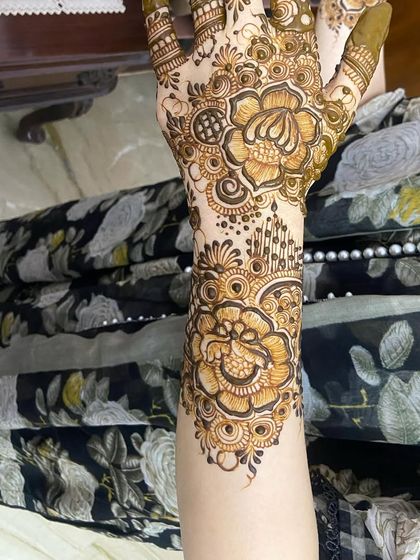 The back of the hand, showing a corresponding floral design.