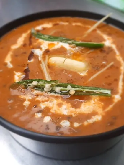This is our Dal Makhani, slow-cooked for hours until it's perfectly creamy and rich. We finish it with a swirl of cream and a pat of butter, making it the ultimate comfort dish.
