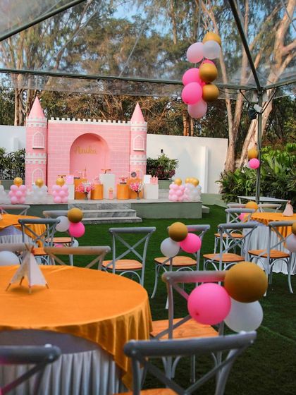 A princess castle-themed birthday party at The Backyard. The pink castle backdrop and colorful balloons transform our lawn into a fairytale setting for your little one.