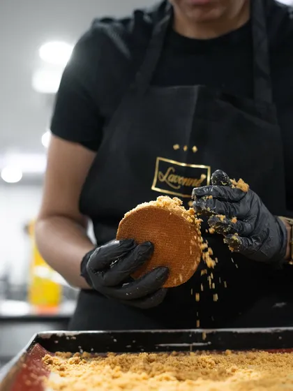 A chef from The Oberoi team applies a crumble coating, a key texture component taught during our advanced pastry workshop.