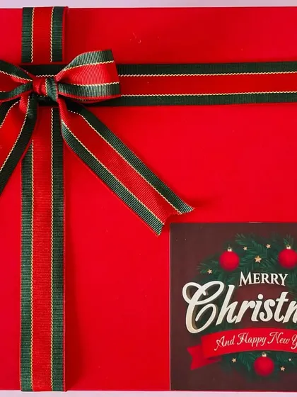 The classic red Christmas box, wrapped with a festive ribbon and a "Merry Christmas" tag. It's the perfect way to send holiday cheer.