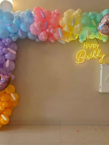 A fun and colorful organic balloon arch with a candy theme. We included donut and pineapple foil balloons and a neon "Happy Birthday" sign to create a sweet and playful vibe.