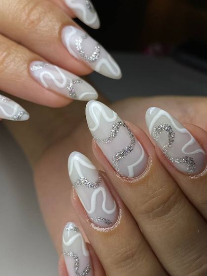 A chic and modern abstract design. This look features a milky white base with flowing white lines and sparkling silver glitter accents for a stylish finish.
