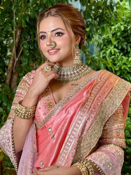 The smile of a bride who feels confident and beautiful. The soft pink saree and minimal glam come together for a look that is both traditional and refreshingly modern.