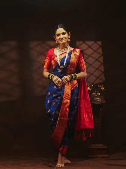 A full-length shot of the model in a classic Nauvari saree, showing the traditional way it's draped.
