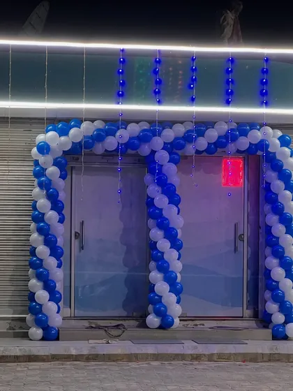 A blue and white balloon arch for the entrance of a new commercial establishment. This is a great way to welcome guests and customers for a grand opening.