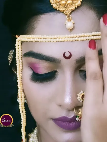 A beautiful bridal portrait with dramatic eye makeup and a deep lip color. The traditional *mundavalya* completes this authentic Maharashtrian bridal style.