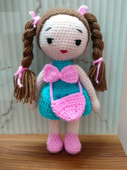 A very pretty doll with braided pigtails and a big pink bow on her dress. She is looking so sweet.