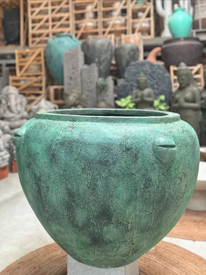 A wide-mouthed planter in a beautiful teal-green finish, perfect for holding a large plant or a small tree.