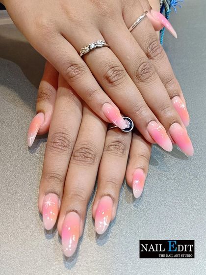 A beautiful pink and orange sunset ombre with a touch of sparkle. The subtle glitter overlay adds a magical shimmer to the warm gradient on these long, tapered nails.