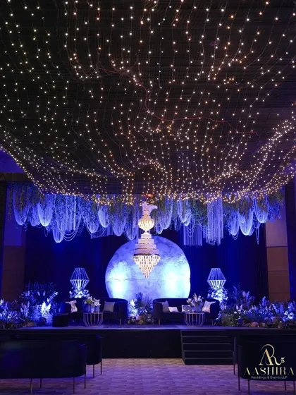 I love creating immersive worlds for evening celebrations. Here, a canopy of starlit fairy lights and hanging floral installations created a celestial dreamscape, with a glowing moon backdrop for a truly magical Sangeet night.