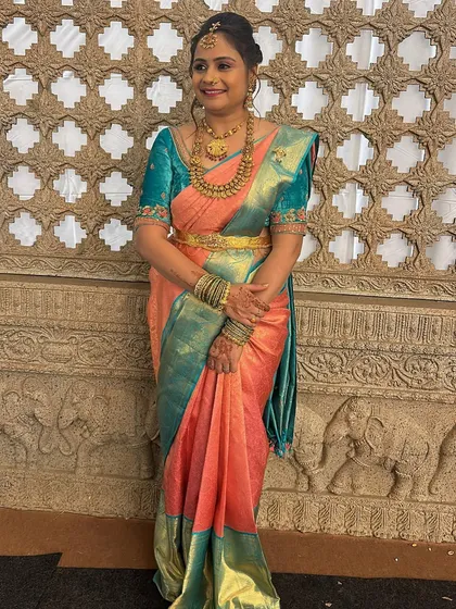 This client looks lovely in a peach and teal Kanjivaram saree. I designed a matching teal blouse with delicate embroidery on the sleeves for a touch of sparkle.