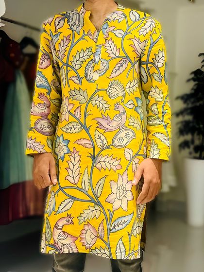 For the men, I offer custom Pen Kalamkari silk kurtas from my Vruksham Series. This vibrant yellow kurta is covered in hand-painted flora and fauna motifs, perfect for making a statement at any festive occasion.