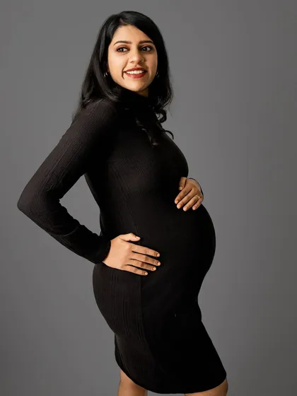 A classic pose with a happy, confident expression. The clean background ensures that you and your beautiful bump are the stars of the show.