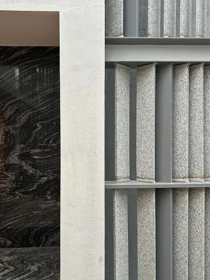A detail where two different stones meet. We love exploring the contrast between the rough, vertical texture of the granite fins and the smooth, dramatic pattern of the dark marble.