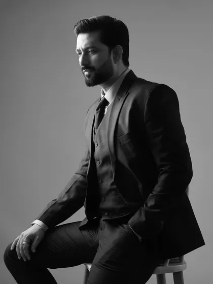 A classic black and white version of the suited portrait of Aadesh Chaudhary, adding a timeless and sophisticated feel.