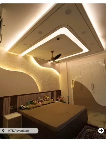 This bedroom features a unique false ceiling design and a textured accent wall with a wave pattern, creating a dynamic and modern look.