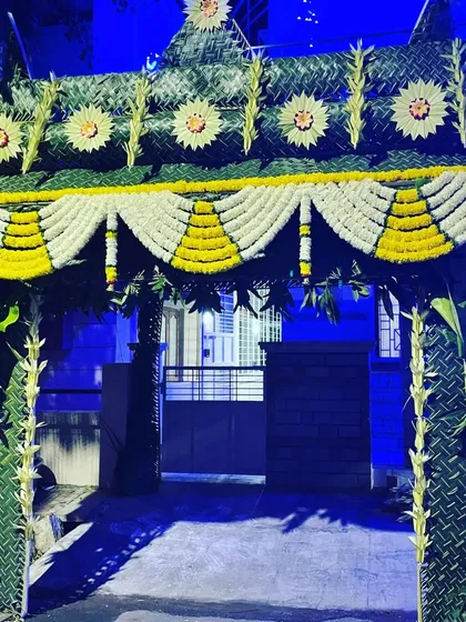 A welcoming entrance toran I built for a home ceremony. This traditional archway is crafted entirely from natural materials, including woven thennai olai (coconut leaves), banana stems, and garlands of yellow and white flowers, setting a festive tone from the moment guests arrive.