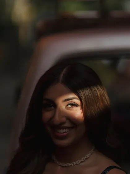 A playful and artistic shot of Sheena. The sliver of light catches her eye and her smile, highlighting the beautiful eye makeup and her joyful expression.