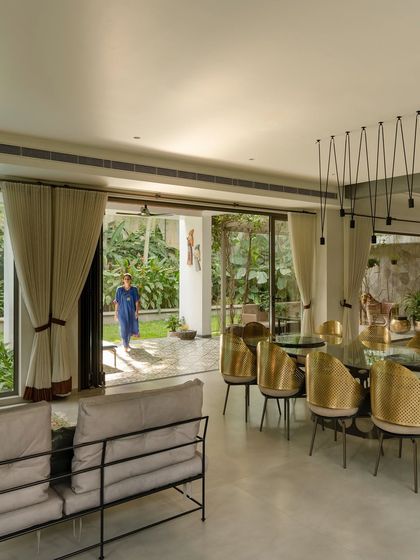 A modern dining room with sliding glass doors that open completely to the patio and garden. The design encourages an effortless flow between indoor dining and outdoor living, perfect for entertaining or daily family life.