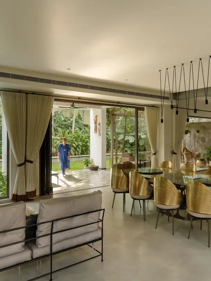 A modern dining room with sliding glass doors that open completely to the patio and garden. The design encourages an effortless flow between indoor dining and outdoor living, perfect for entertaining or daily family life.