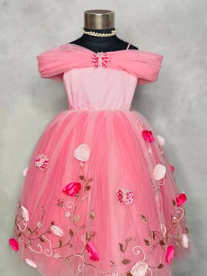 Straight out of a storybook. Our "Princess Diaries" dress in pink features an elegant off-the-shoulder neckline and a tulle skirt embroidered with delicate vines and 3D flowers.