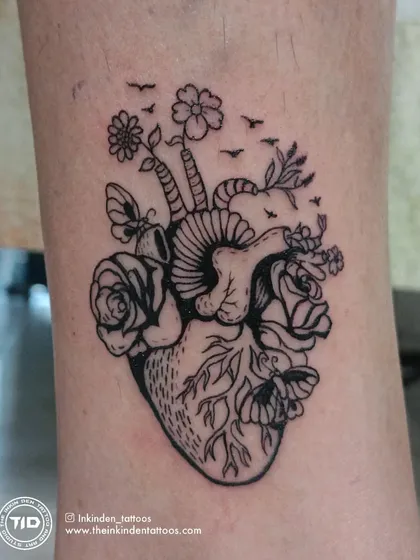 A close-up of the anatomical heart with flowers tattoo.