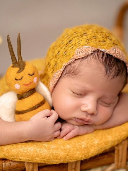 As sweet as honey. This adorable setup with a little bee theme and warm yellow tones perfectly captures the sweetness of this sleeping newborn.