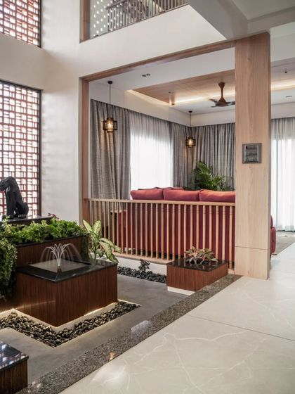 The interior living space is organized around a double-height courtyard with a water feature, bringing light, air, and the sound of water into the home.