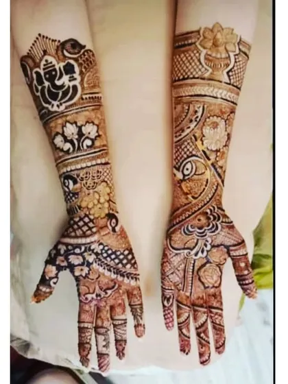 A beautiful bridal mehandi combining auspicious symbols. This design features a prominent Lord Ganesha figure for blessings, along with floral patterns and traditional motifs.