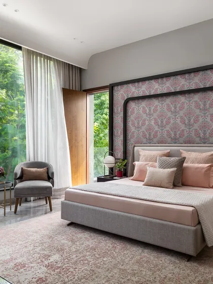 A bedroom should be a personal sanctuary with a deep connection to the outdoors. For this daughter's suite, we designed a custom headboard that frames the space elegantly, while the floor-to-ceiling window brings in serene views of the lush greenery, creating a calm and inspiring retreat.