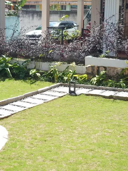 This image highlights the clean, green expanse of the lawn, neatly edged and providing a perfect setting for the stone pathway and well.