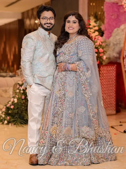 A classic couple portrait from a Roka ceremony, showcasing their coordinated pastel outfits and the floral decor.