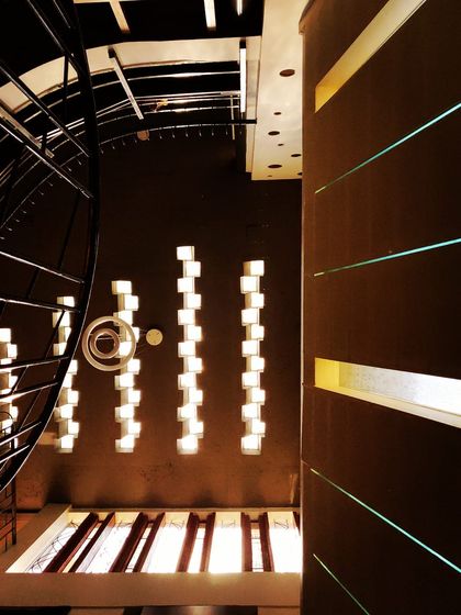 Sunshine through slits. This abstract view from a stairwell shows how even small, rhythmic openings in a wall can create powerful patterns of light, adding depth and intrigue to a dark space.