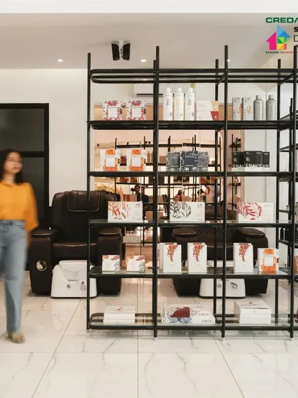 The shelving unit serves as a functional and stylish backdrop to the pedicure and manicure area.