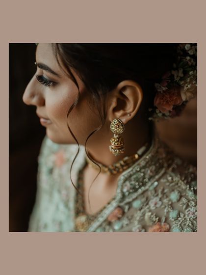 A beautiful profile shot of the bride, highlighting her elegant hairstyle with fresh flowers and her delicate earrings.