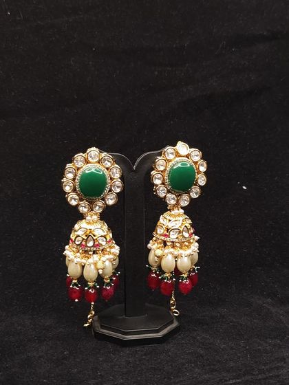 These jhumkas combine red and green stones with pearls, a classic combination available for rent.