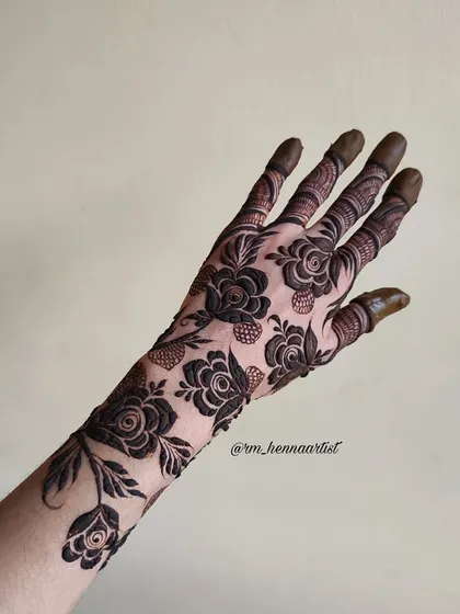 A beautiful back-hand design featuring bold, black roses. This style is very striking and modern, perfect for someone who wants to make a statement.