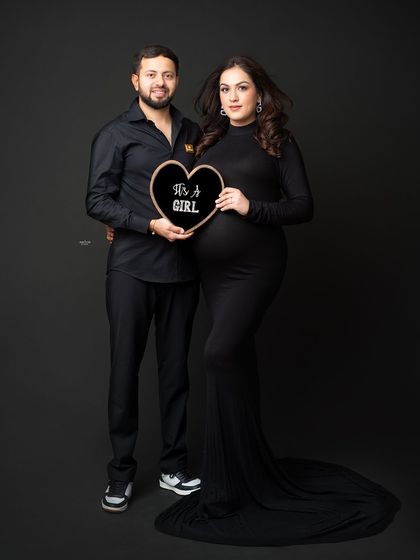 A fun gender reveal shot for this happy couple. Announcing "It's a Girl!" with a cute heart-shaped sign.